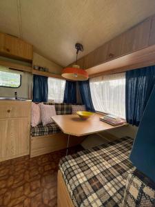 a small room with a table in a rv at Vintage caravan in old orchard at farm Huize Blokland in Hem
