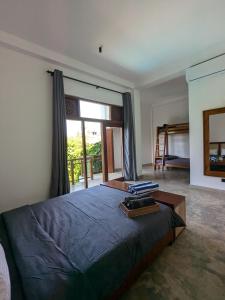 a bedroom with a bed and a large window at LoSu Polhena in Polhena