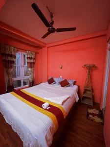 una camera da letto con un grande letto con pareti rosse di Hotel New Pokhara Peace a Kathmandu