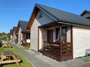 a row of cottages with a picnic table at Domki letniskowe MagNat 700m od morza! in Rusinowo +50 photos