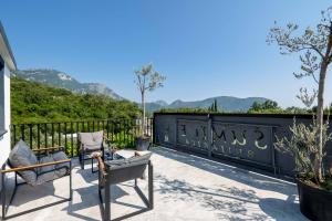 a patio with chairs and a fence with mountains in the background at Sumice Inn in Petrovac na Moru