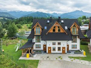a large house with a playground in front of it at Apartamenty Księżycowe SPA - Tatra View - Golden Apartments in Zakopane