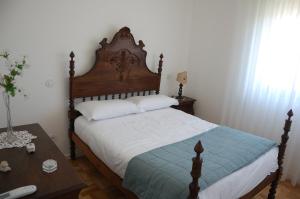 een slaapkamer met een bed met een houten hoofdeinde en een tafel bij Correia Villa in Barcelos +57 foto's