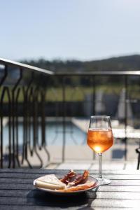 een glas wijn en een bord eten op tafel bij Correia Villa in Barcelos