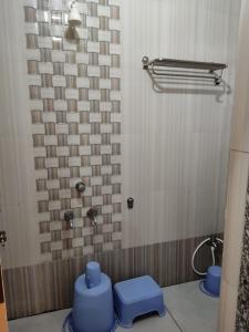 a bathroom with two blue stools and a shower at Hotel Yogiraj in Shirdi