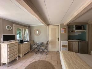 a bedroom with a bed and a desk and a television at Hôtel Miramar in Vence