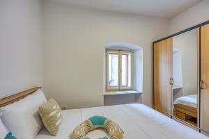 a bedroom with a bed and a window at Old Bay Leave Town Apartment - Happy Rentals in Mali Lošinj +19 photos