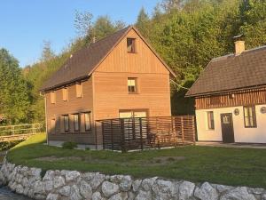 a large wooden house next to a stone wall at Sacherl am Bacherl in Rosenau am Hengstpass