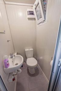 a small bathroom with a toilet and a sink at Каравани AVI IRIS Фичоза in Varna City +49 photos