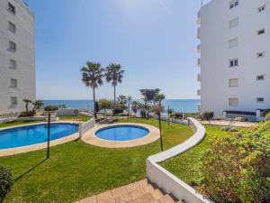 a swimming pool in a park next to a building at Apartment on Beach Mijas in Mijas Costa