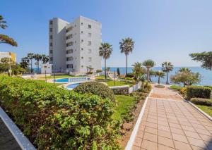 a walkway in front of a building and the ocean at Apartment on Beach Mijas in Mijas Costa