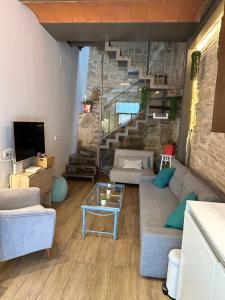 a living room with a couch and a staircase at Casa de diseño 200m Mezquita 2 rooms & 2 bathrooms in Córdoba