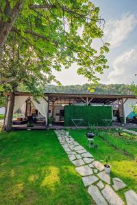 a backyard with a tent and a lawn at Каравани AVI IRIS Фичоза in Varna City