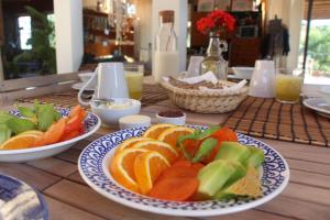 a wooden table with plates of fruit on it at Biovilla Sustentabilidade in Palmela