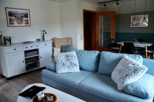 a living room with a blue couch and a table at Ferienwohnung Brehm in Bad Staffelstein