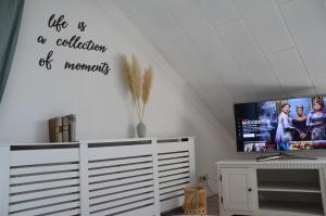 a living room with a flat screen tv on a wall at Ferienwohnung Brehm in Bad Staffelstein
