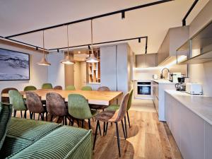 una sala da pranzo e una cucina con tavolo e sedie di Chalet familial 12 pers avec jacuzzi et ski-in/ski-out - FR-1-613B-40 a Les Bruyères
