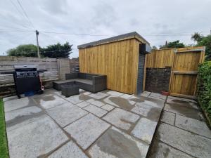 a backyard with a grill and a wooden fence at Homely 3 Bedroom home near town centre & only 1 mile from Bike Park Wales in Merthyr Tydfil
