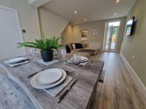 a dining table with plates and wine glasses on it at Homely 3 Bedroom home near town centre & only 1 mile from Bike Park Wales in Merthyr Tydfil