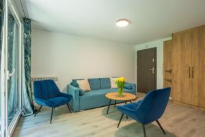 a living room with a blue couch and two blue chairs at VacationClub - Podgórzyńska 6A Apartament 5 in Jelenia Góra