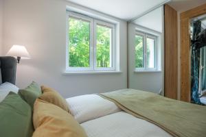 a bedroom with a bed and two windows at VacationClub - Podgórzyńska 6A Apartament 5 in Jelenia Góra +15 photos