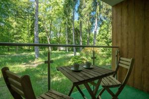a wooden table and two chairs on a porch with a window at VacationClub - Podgórzyńska 6A Apartament 5 in Jelenia Góra