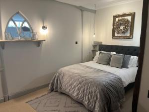 a bedroom with a bed and a mirror on the wall at The Old Gallery in Winchcombe