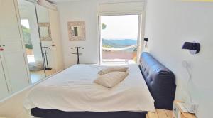 Sant Cebrià de VallaltaにあるCasa Blancaの大きな窓のある部屋にある大きなベッド