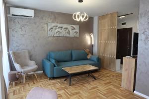 a living room with a blue couch and a table at Apartments near to Burgas Free University in Burgas