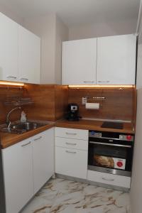 a kitchen with white cabinets and a sink at Apartments near to Burgas Free University in Burgas +27 photos