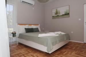 a bedroom with a large bed with a wooden floor at Apartments near to Burgas Free University in Burgas
