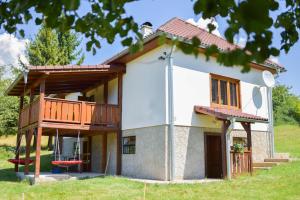 a house with a porch and a deck at Chalupa na lúčnych kvetoch in Dobroč