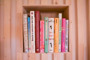 a row of books on a book shelf at Chalupa na lúčnych kvetoch in Dobroč