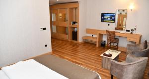 a room with a bed and a desk with a computer at Classy Hotel Erbil in Erbil