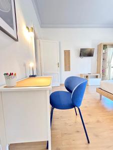 a blue chair sitting next to a desk in a room at Flaminio Luxury Home - City Center in Rome