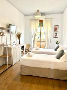 a bedroom with two beds and a desk and a window at Flaminio Luxury Home - City Center in Rome