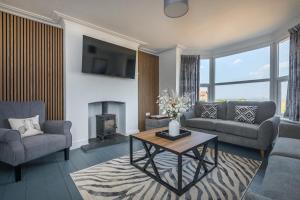 a living room with couches and a table and a fireplace at Seaview at No.5 Mundesley in Mundesley