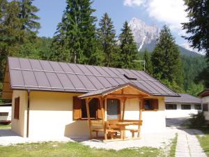 a house with a solar roof with a picnic table at Camping Castelpietra in Fiera di Primiero