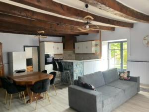 a living room with a couch and a table at Gîte le temps de vivre in Pressac