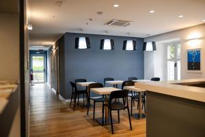 a dining room with tables and chairs and a blue wall at Hotel Tritone in Trieste
