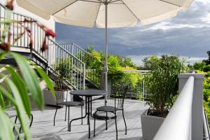 a patio with tables and chairs and an umbrella at Hotel Tritone in Trieste