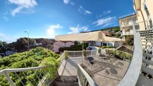 a balcony with an umbrella and tables and chairs at Hotel Tritone in Trieste