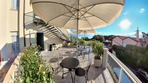 a balcony with tables and chairs and an umbrella at Hotel Tritone in Trieste