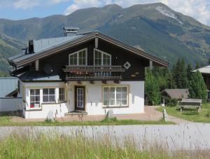 een wit en zwart huis met bergen op de achtergrond bij Haus 129 Top 1 in Krimml