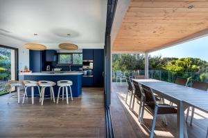 une cuisine ouverte et une salle à manger avec une table et des chaises dans l'établissement Villa de la Madrague Vue Mer à 200m de la Plage sur La Presqu' île de Giens Sea and Mountain Pleasure, à Hyères
