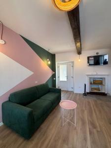 a living room with a green couch and a table at LevOasi 7 - Garden, jacuzzi and sauna escape in Levo