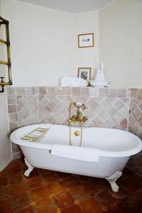 a white bath tub in a bathroom with a tile wall at La Verrière in Crestet +36 photos