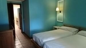 ein Schlafzimmer mit zwei Betten und einer blauen Wand in der Unterkunft Apartamentos Jasmund - Bungalow 87 in San Fernando