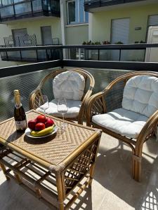 a table with a plate of fruit and a bottle of wine at DIVE RIVE LUXURY Apartment in Desenzano del Garda +9 photos