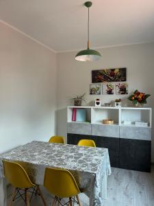 a dining room with a table and yellow chairs at 2 Cuori al Lago - Appartamento in villetta singola in Mandello del Lario +8 photos